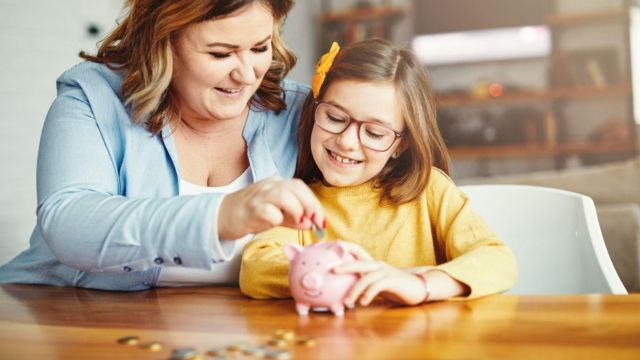 a woman teaching a girl about money