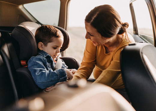 Mom strapping child into carseat