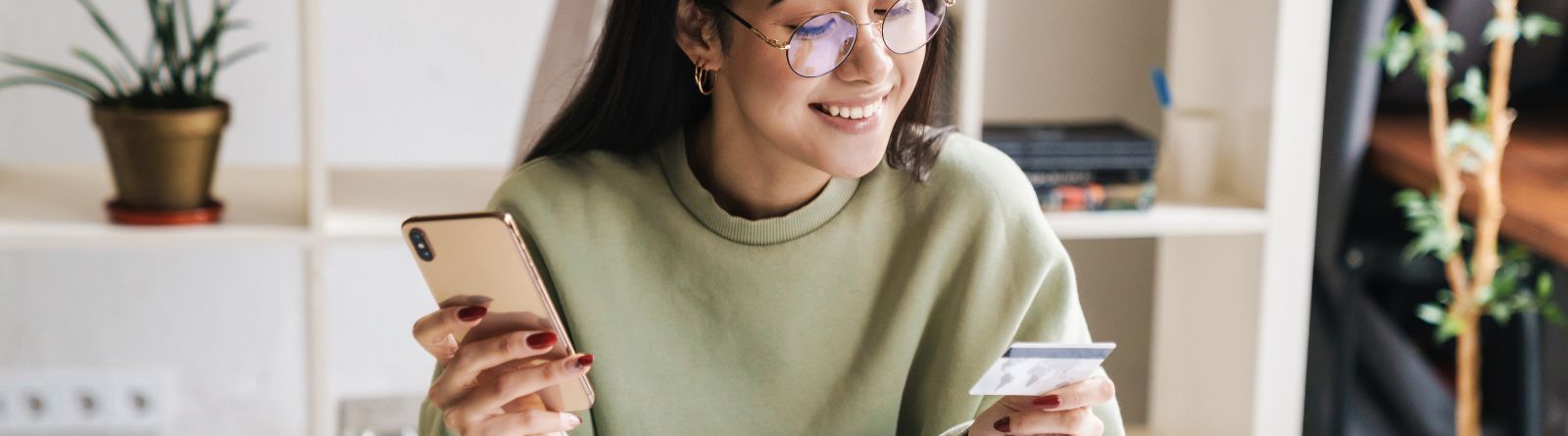 A young woman holding a debit card
