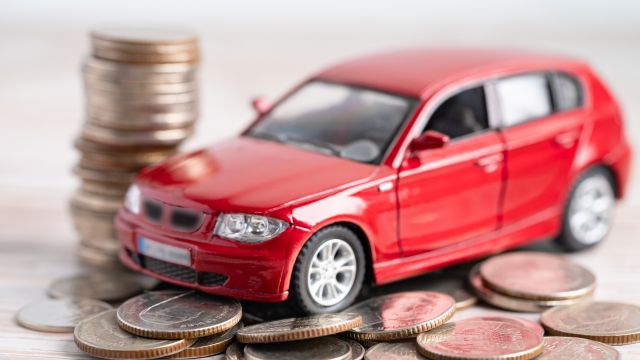 a toy car sitting on top of a pile of change